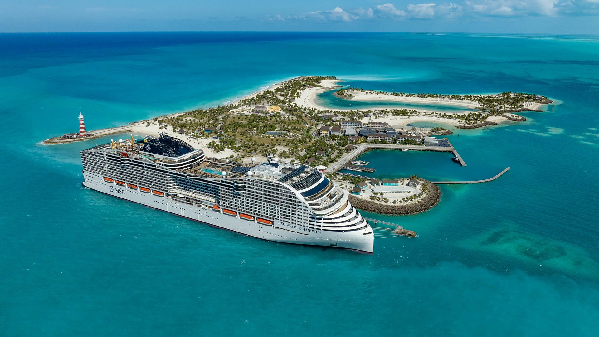 Navio MSC World America junto a uma ilha de águas turquesa